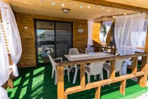 a table and chairs on the porch of a cabin at ECO Hоuses - Camping Gradina in Chernomorets