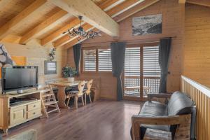 a living room with a television and a table with chairs at Laackerhof in Bettmeralp