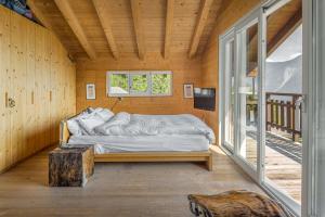 a bed in a room with a large window at Rupicapra in Bettmeralp