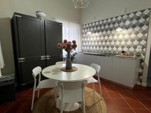 une cuisine avec une table et un vase de fleurs. dans l'établissement LaMalatestina Suite - Apartment in front of the Castle, à Rimini