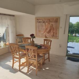 un comedor con mesa, sillas y una pintura en Haus KanaleGrande, en Haltern