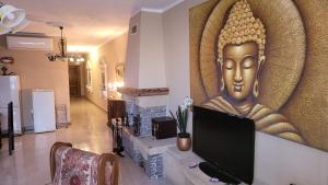 a living room with a large painting of a statue at Lotus Apartment in Tad-Duluri