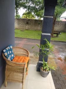 a porch with a wicker chair and a plant at Keresia's guestwing in Lusaka