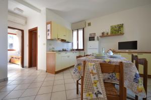 una cucina e una sala da pranzo con tavolo e sedie di Villaggio Le Palme a Lignano Sabbiadoro