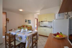 una cucina con tavolo e ciotola di frutta di Villaggio Le Palme a Lignano Sabbiadoro