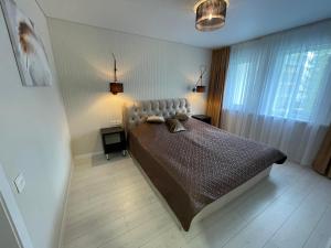 Un pat sau paturi într-o cameră la Ly apartamentai
