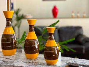three vases sitting on top of a table at Hotel São Pedro in São Pedro