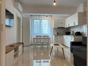 a kitchen and living room with a table and a couch at GLAM Apartments Palas Mall Center Area in Iaşi