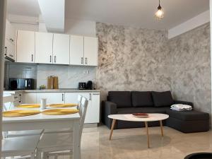 a kitchen and a living room with a couch and a table at GLAM Apartments Palas Mall Center Area in Iaşi