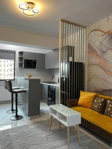 - un salon avec un canapé et une table dans l'établissement GLAM Apartments Palas Mall Center Area, à Iaşi