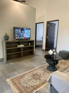 sala de estar con TV de pantalla plana y sofá en Lovely 2-bedroom holiday home with free parking., en Panadura