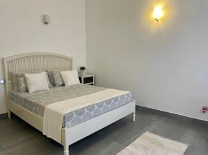 1 dormitorio con 1 cama en una habitación blanca en Lovely 2-bedroom holiday home with free parking., en Panadura