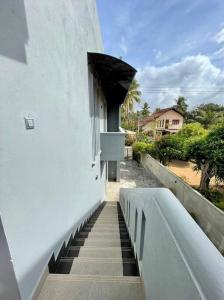 una escalera que conduce a un edificio blanco con ventana en Lovely 2-bedroom holiday home with free parking., en Panadura