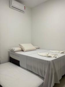 Habitación blanca con 2 camas y calentador en SUITES PERTO DO MAR en Porto de Galinhas