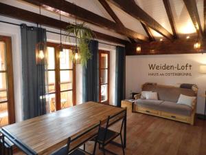 a living room with a wooden table and a couch at Haus am Osterbrünnl in Ruhmannsfelden