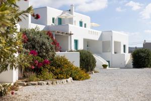 a white house with flowers in front of it at Ploes Seaside Houses in Plaka