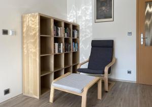 Pokój z krzesłem i półką na książki w obiekcie Slunný a vzdušný Apartmán Astra - by Relax Harrachov w mieście Harrachov