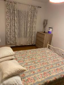 - une chambre avec un lit, une commode et une fenêtre dans l'établissement Apartamento F.A, à Pedrógão