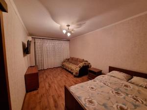 1 dormitorio pequeño con 1 cama y 1 sofá en 1-комн центр, 45 квартал, Вокзал, Бухар-Жырау 69 en Karagandá