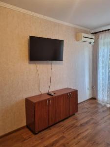 ein Wohnzimmer mit einem Flachbild-TV an der Wand in der Unterkunft 1-комн центр, 45 квартал, Вокзал, Бухар-Жырау 69 in Qaraghandy