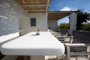 a white table and chairs on a patio at Ploes Seaside Houses in Plaka
