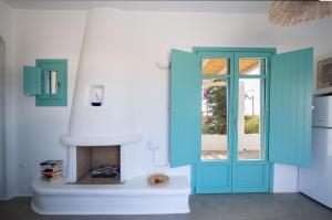 a room with a blue door and a fireplace at Ploes Seaside Houses in Plaka