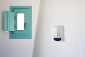 a wall with a small sailboat vase on a wall at Ploes Seaside Houses in Plaka