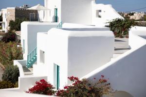 a row of white buildings with flowers on them at Ploes Seaside Houses in Plaka
