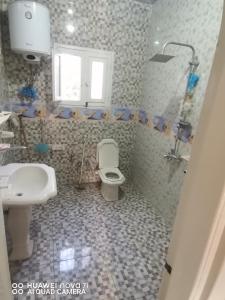 uma casa de banho com um WC e um lavatório em استراحه وفيلا ومكان ترفيهي 
