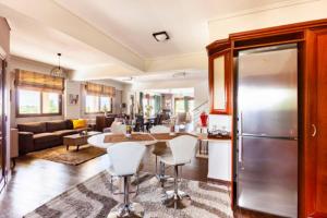 a kitchen and living room with a refrigerator and a table at Villa Anemos in Nafplio