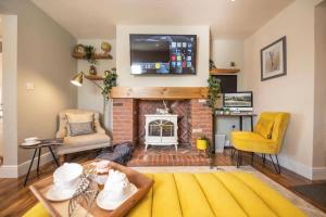 a living room with a fireplace and a tv on the wall at Stunning Views, Hot Tub, 5 minutes to Chester 