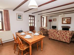 a living room with a wooden table and chairs at Ty Canol in Mathry