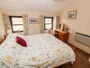 a bedroom with a large bed and two windows at Ty Canol in Mathry