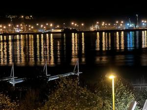 uma grande massa de água à noite com luzes em Prado-Gijon em Gijón