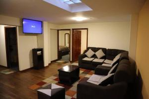 ein Wohnzimmer mit einem Sofa und einem Flachbild-TV in der Unterkunft Departamentos independientes en Zona central in La Paz