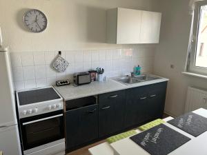 a kitchen with a stove and a sink and a clock at Stylische Ferienwohnung gratis WIFI & Netflix nähe Bahnhof in Zwickau