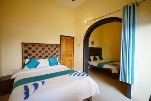 a bedroom with two beds and a large mirror at Sunset & Waves Resort in Mandrem