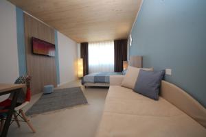 Habitación pequeña con sofá y cama. en Ohana Holiday Rooms, en Rosolina Mare