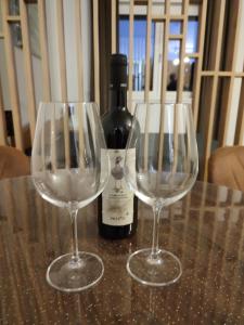 two wine glasses sitting on a table with a bottle of wine at Twin mountain in Kopaonik +18 photos