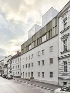 ein großes weißes Gebäude in einer Stadtstraße in der Unterkunft HÜBSCHES APARTMENT im Herzen von Linz in Linz