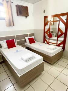 twee bedden in een kamer met een spiegel bij Hotel City I in Santo André