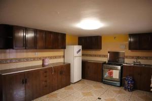 a kitchen with wooden cabinets and a white refrigerator at Departamentos independientes en Zona central in La Paz
