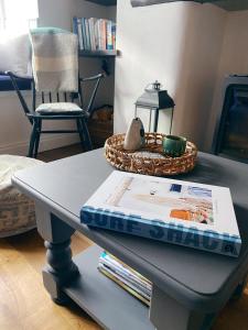 a table with a book and a basket on top of it at Shrimp Cottage - 3 bed renovated cottage with stunning sea views in Staithes
