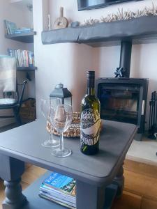 a bottle of wine and two glasses on a table at Shrimp Cottage - 3 bed renovated cottage with stunning sea views in Staithes