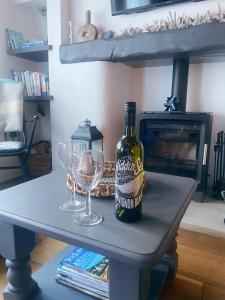 eine Flasche Wein und zwei Gläser auf einem Tisch in der Unterkunft Shrimp Cottage - 3 bed renovated cottage with stunning sea views in Staithes