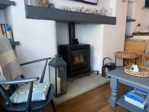 a fireplace in a living room with a table and a chair at Shrimp Cottage - 3 bed renovated cottage with stunning sea views in Staithes