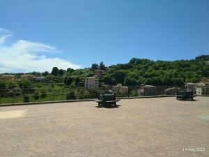 Dos bancos sentados en un patio con vista a la ciudad. en ALLOGGIO BLU nel CUORE DI SORIANO, en Soriano nel Cimino 4 fotos más