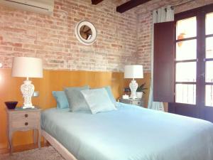 a bedroom with a blue bed and a brick wall at Lux Apartments Barcelona in Barcelona