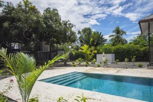 a pool in the backyard of a house with trees at Yuli Hotel in Uvita