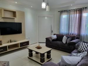 ein Wohnzimmer mit einem Sofa und einem TV in der Unterkunft Casa Familiar em ótima Localização in Foz do Iguaçu